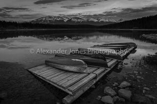 boats set against gloomy mountains during dusk in canadian rocky mountains