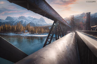 canmore engine bridge during sunset in canmore alberta sun setting over snow capped mountains