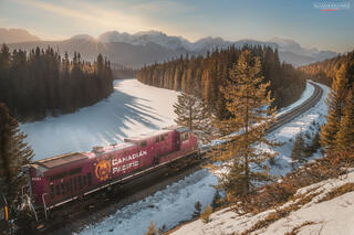 train going around a bend in the tracks during sunset in the banff national park during a spring sunset