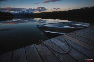 Boat sitting idle in dock during a mountain sunrise at Maligne Lake in Jasper National Park in the Canadian Rocky Mountains