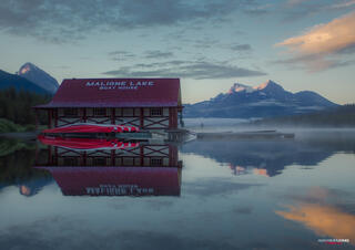 a hazy sunrise at maligne lake in jasper national park