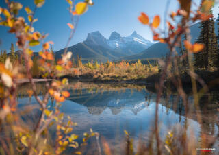 Three sisters during fall orange leaves and blue lake