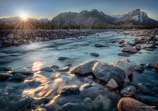 Sun going over horizon with light shining on river Jasper National Park Canadian Rockies