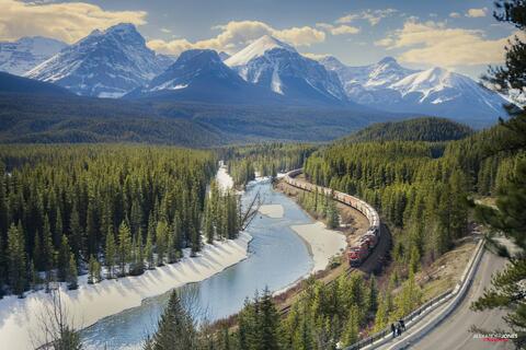 a train going through morant's curve in banff national park. 