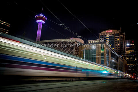 Long exposure of calgary metro train with calgary tower in background in the city of calgary canada