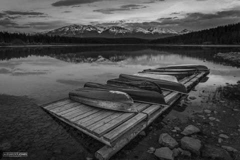 boats set against gloomy mountains during dusk in canadian rocky mountains