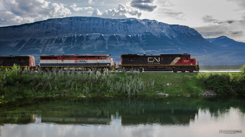 CN Freight train with mountain in background with mirror reflection on a lake in Jasper National Park in Canada