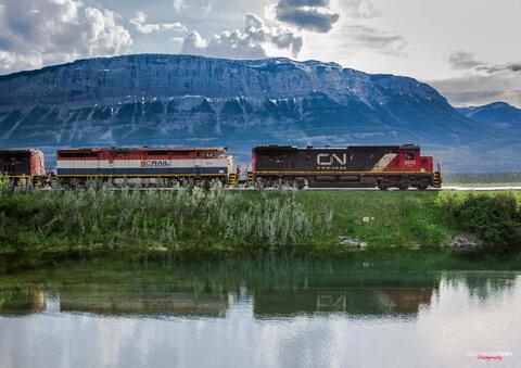 CN Freight train with mountain in background with mirror reflection on a lake in Jasper National Park in Canada