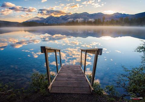 mountain reflections on lac beauvert during sunrise in jasper national park in canadian rocky mountains