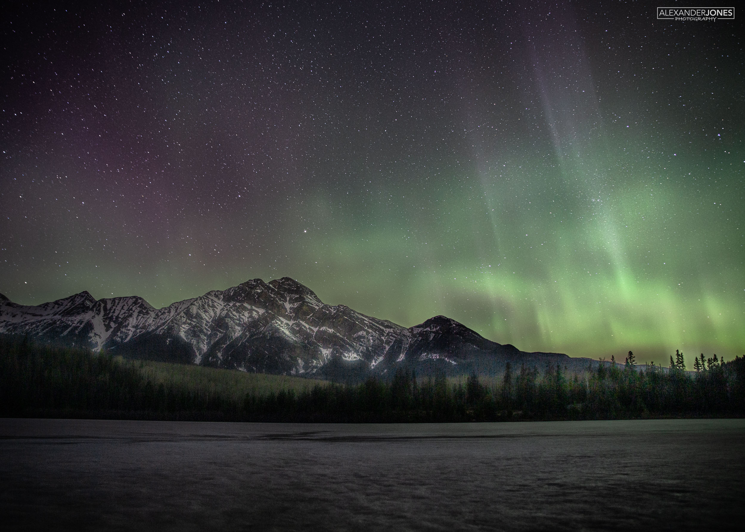 northern lights and aurora borealis over pyramid mountain in jasper national park in canadian rocky mountains