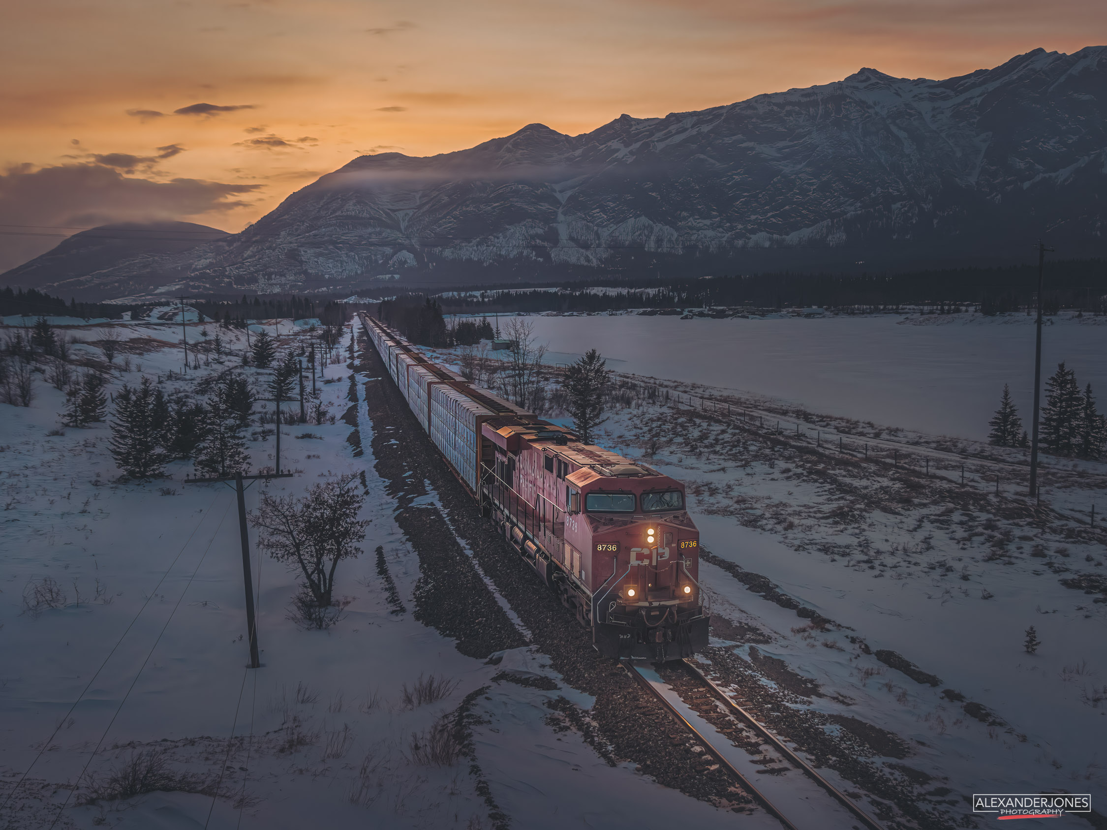 train photographed during dusk set against snow capped mountains