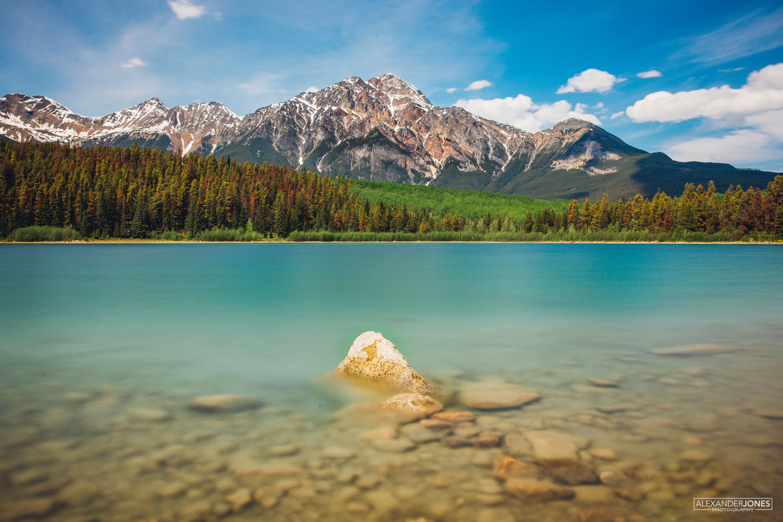 bright summer lake with snow capped mountains in canadian rocky mountains in jasper national park