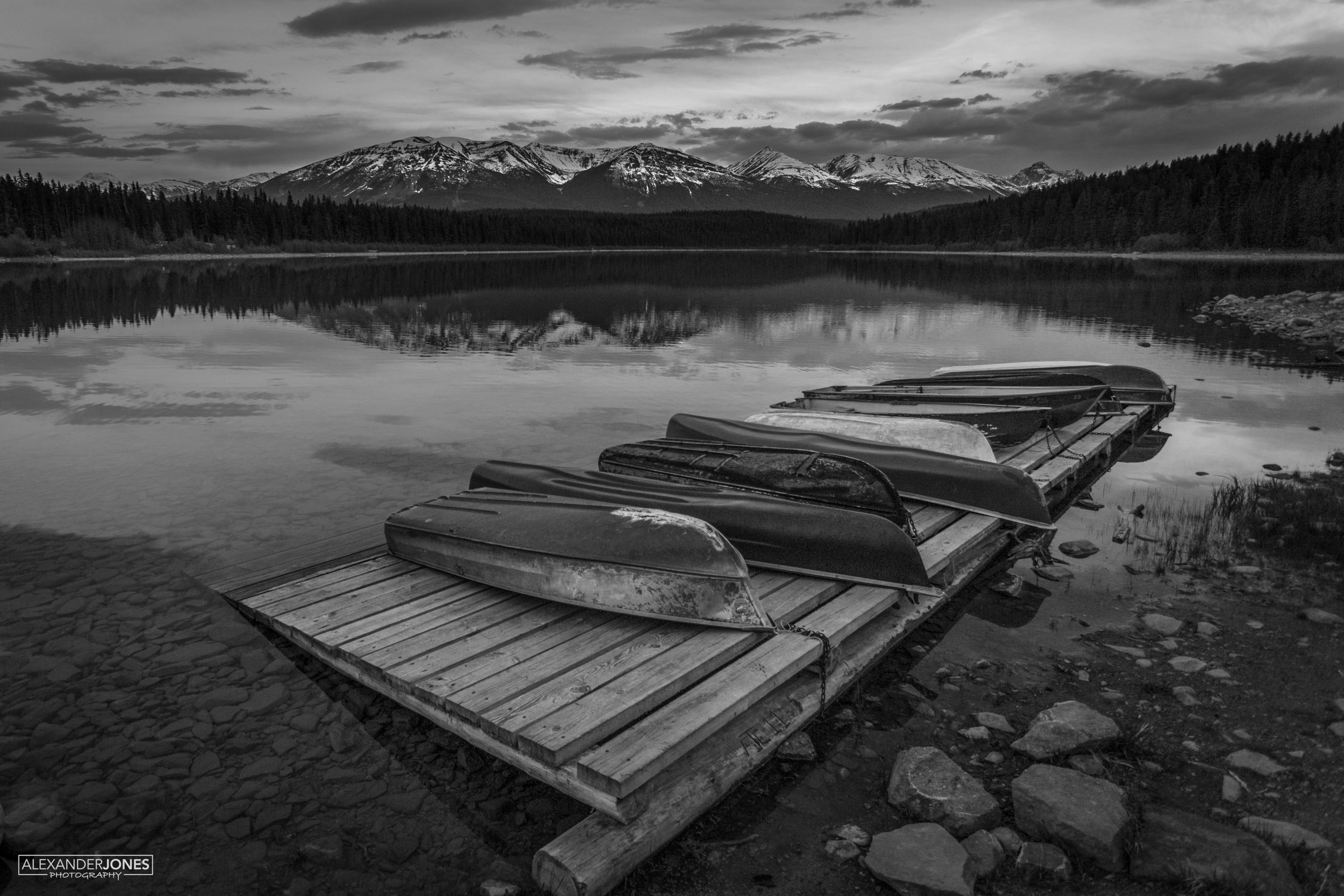 boats set against gloomy mountains during dusk in canadian rocky mountains