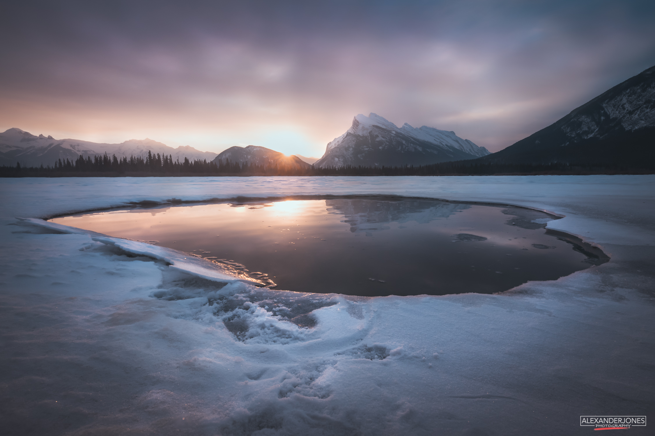 Sun rising at Vermillion Lake in Banff National Park next to Rundle Mountain