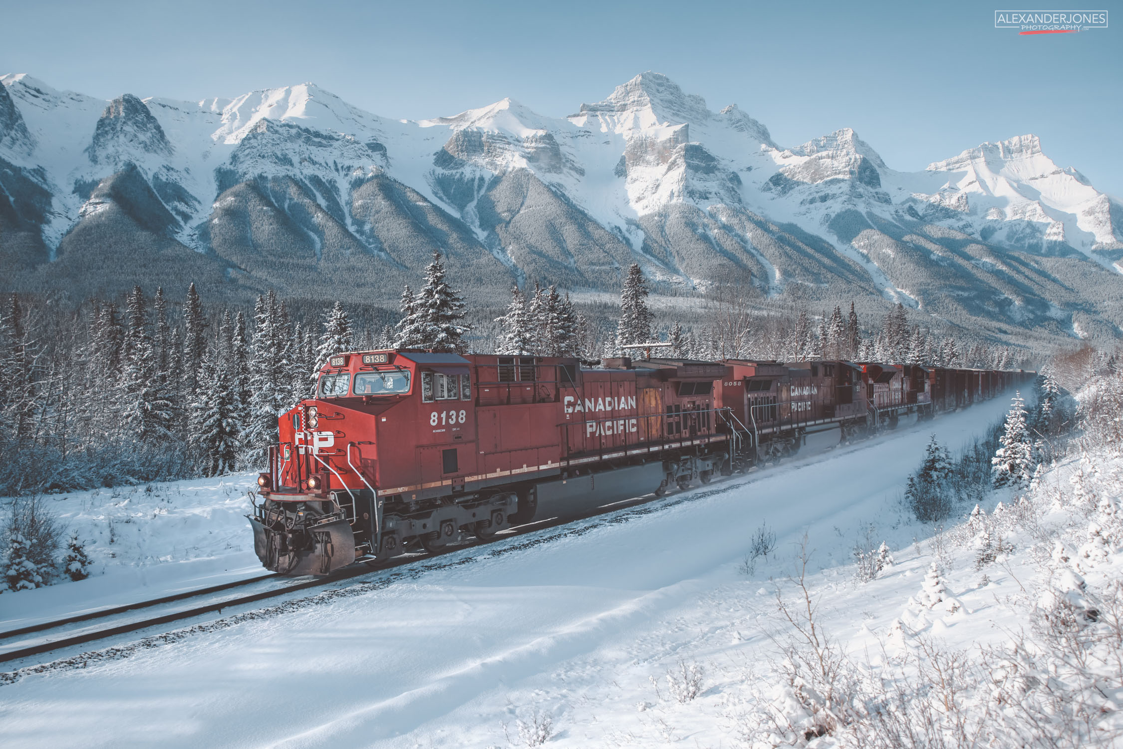 CP Winter Train A freight train going past snow capped mountains in Canmore alberta canada in winter